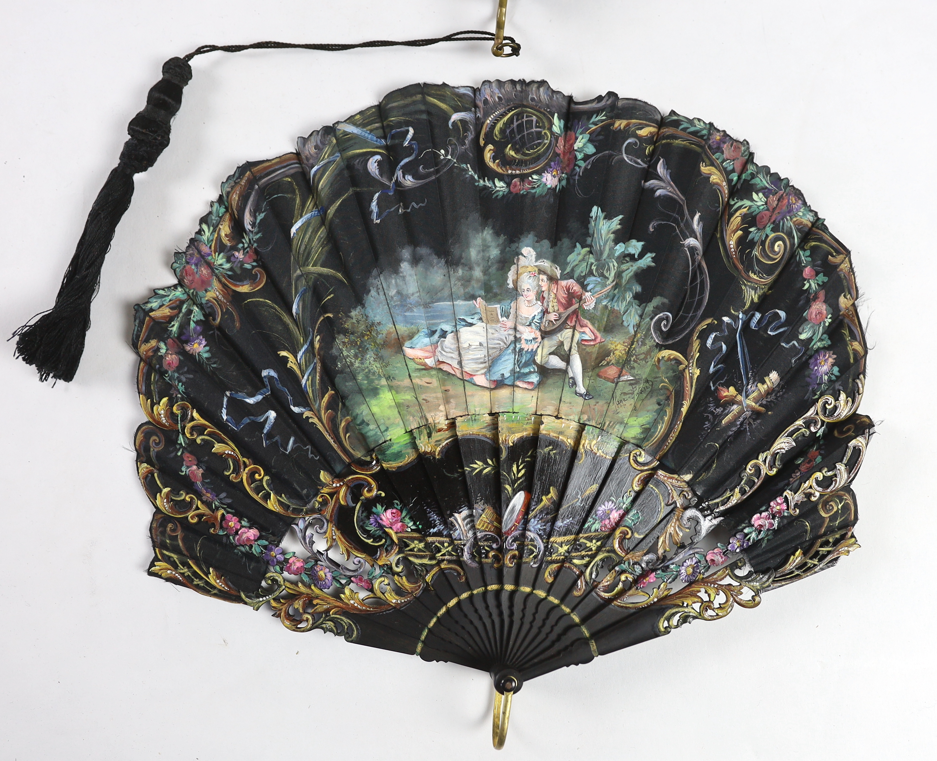 A late 19th century hand painted shaped and carved figurative fan, signed, together with a lacquer and mother of pearl fan, with matching leaf and guard decoration